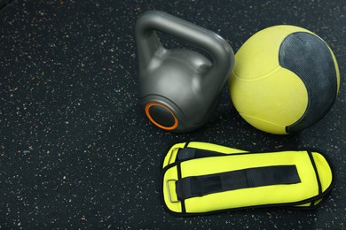 Photo of Yellow medicine ball, kettlebell and weighting agents on floor, space for text