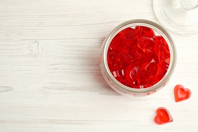 Tasty heart shaped jelly candies on white table, flat lay. Space for text