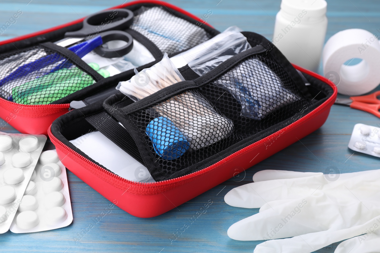 Photo of First aid kit on blue wooden table, closeup