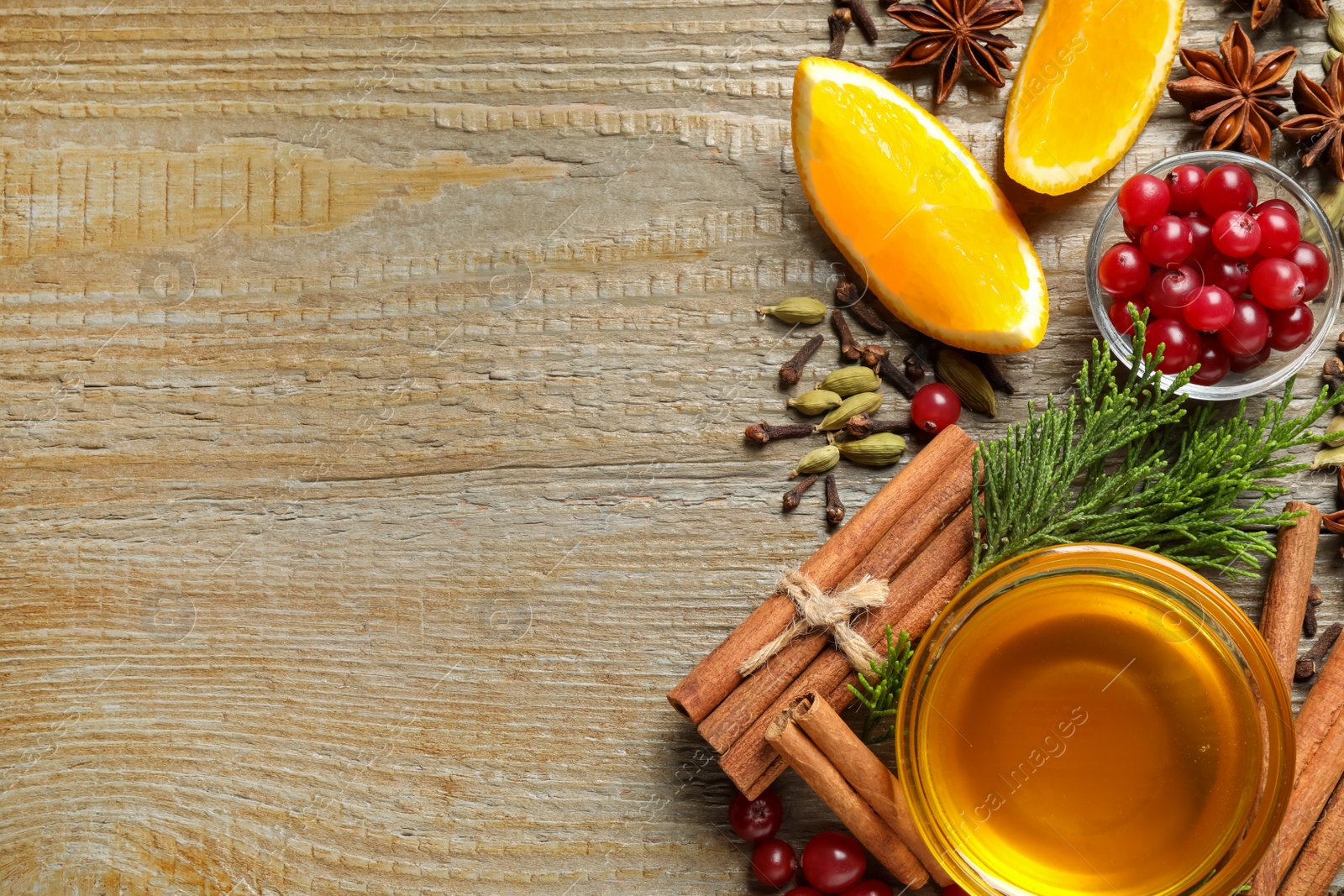 Photo of Flat lay composition with mulled wine ingredients on wooden table. Space for text