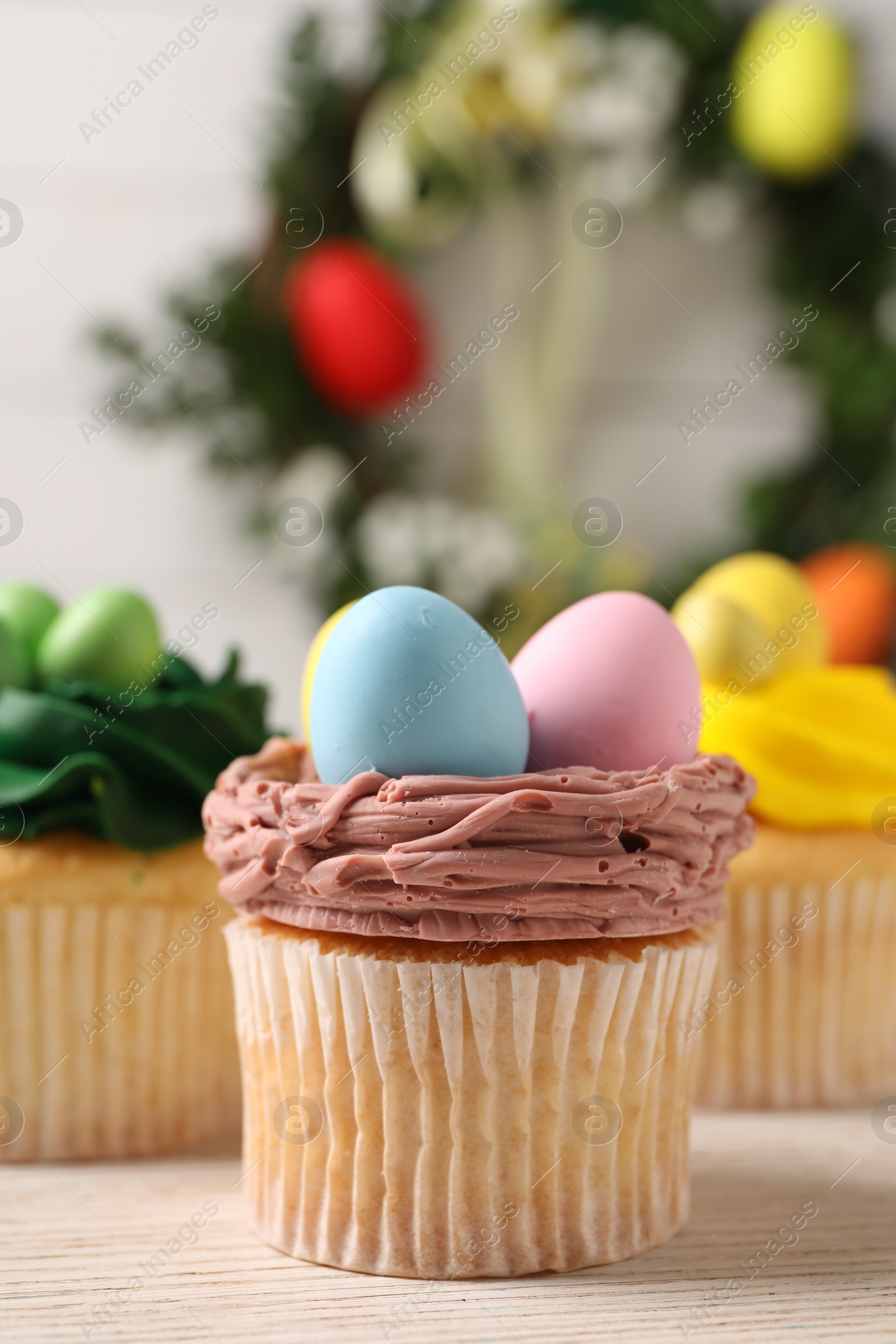 Photo of Tasty decorated Easter cupcakes on wooden table, closeup