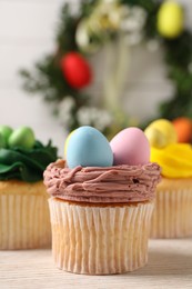 Tasty decorated Easter cupcakes on wooden table, closeup