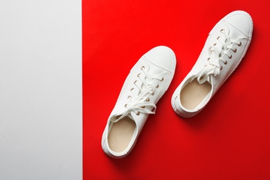 Stylish sneakers on color background, top view with space for text