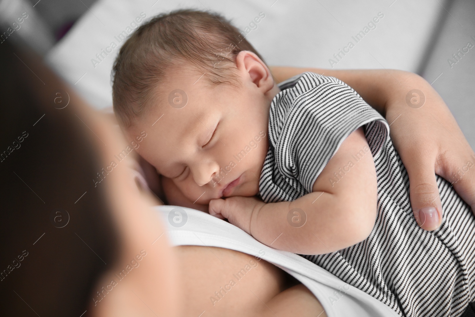 Photo of Young woman holding her newborn baby, closeup