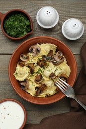 Photo of Delicious ravioli with mushrooms served on wooden table, flat lay