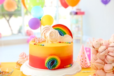 Table with birthday cake and delicious treats indoors