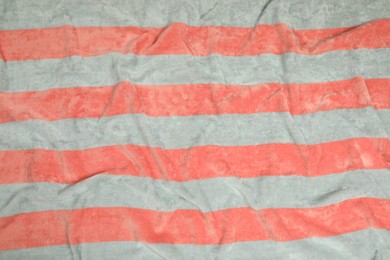 Photo of Crumpled striped beach towel as background, top view