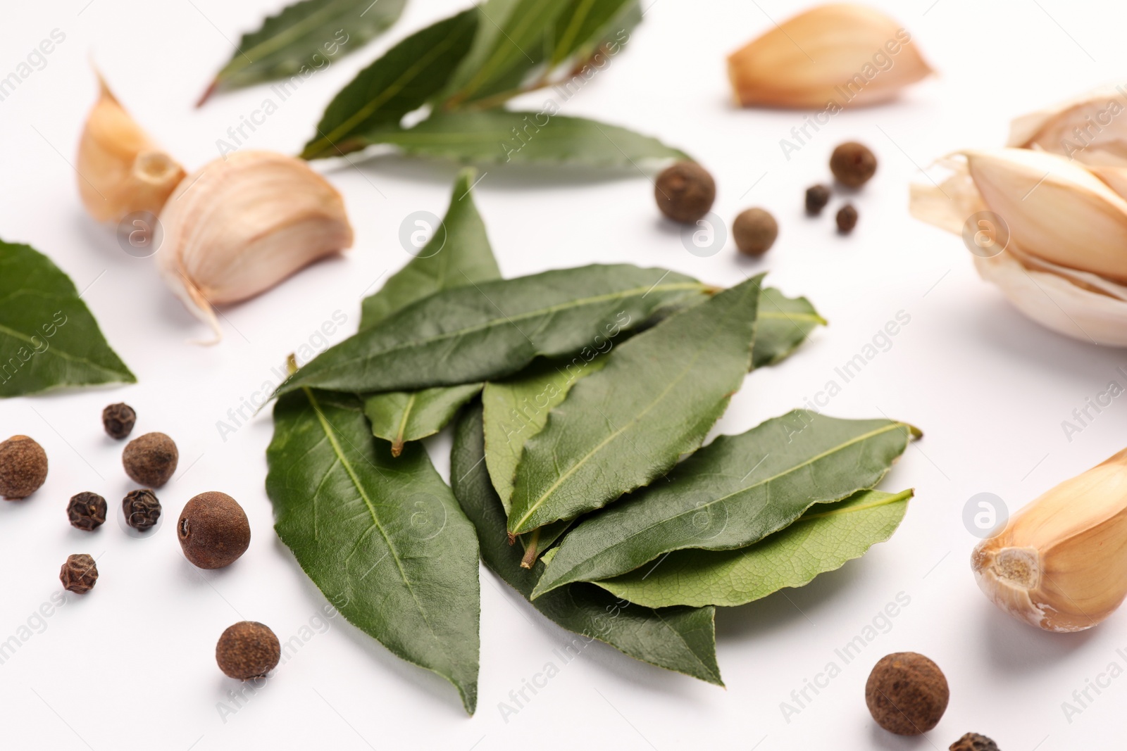 Photo of Aromatic bay leaves and spices on white background