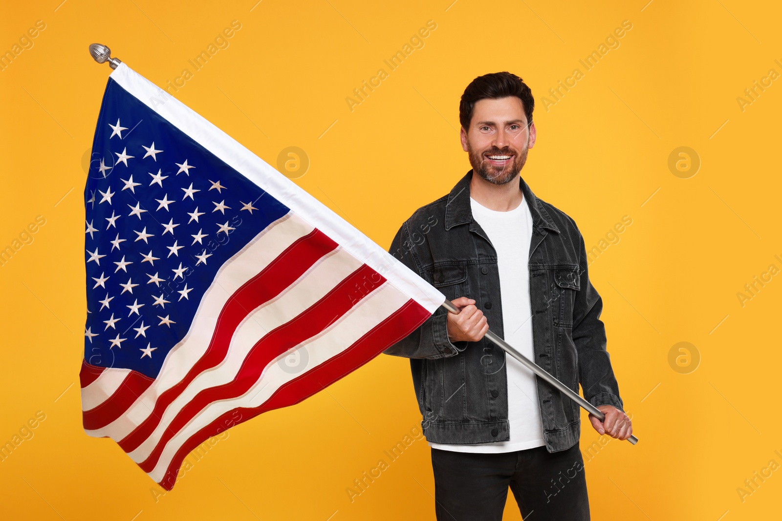 Photo of 4th of July - Independence Day of USA. Happy man with American flag on yellow background