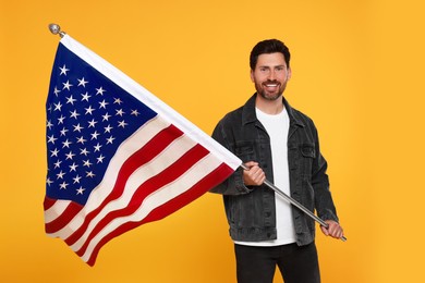 Photo of 4th of July - Independence Day of USA. Happy man with American flag on yellow background