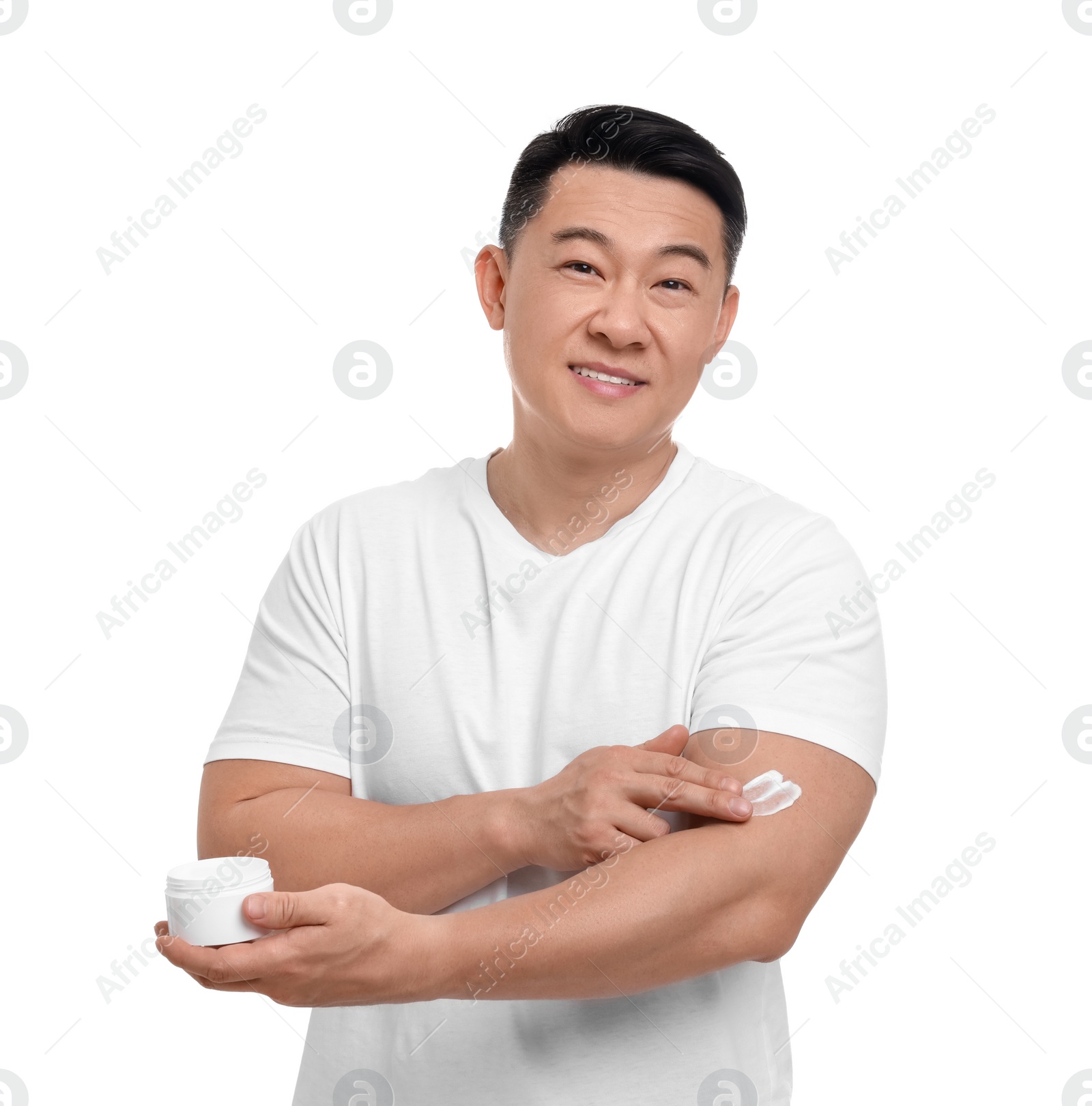 Photo of Handsome man applying body cream onto his arm on white background
