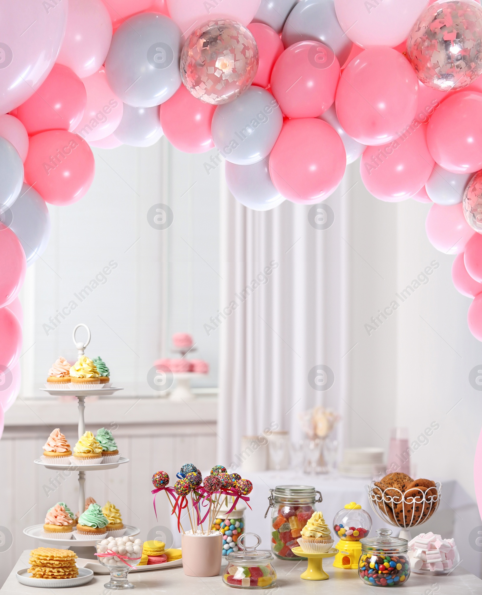 Image of Baby shower party for girl. Tasty treats on table in room decorated with balloons