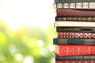 Image of Collection of different books on blurred green background, space for text