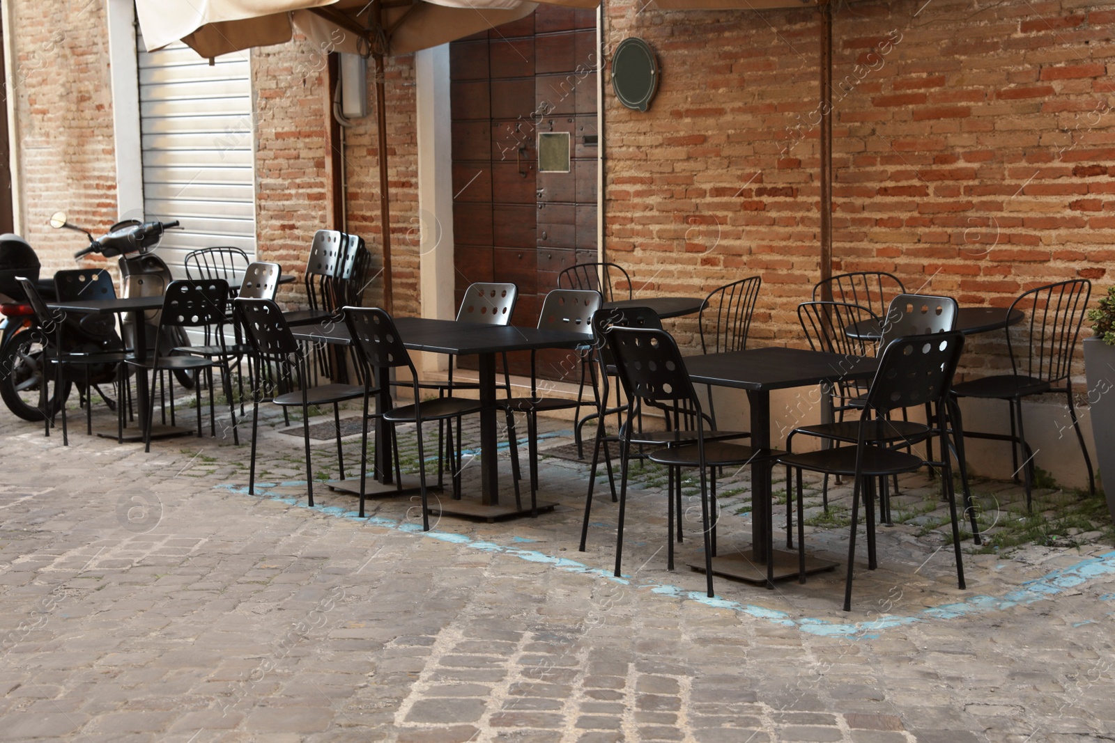 Photo of Tables and chairs near building. Outdoor cafe