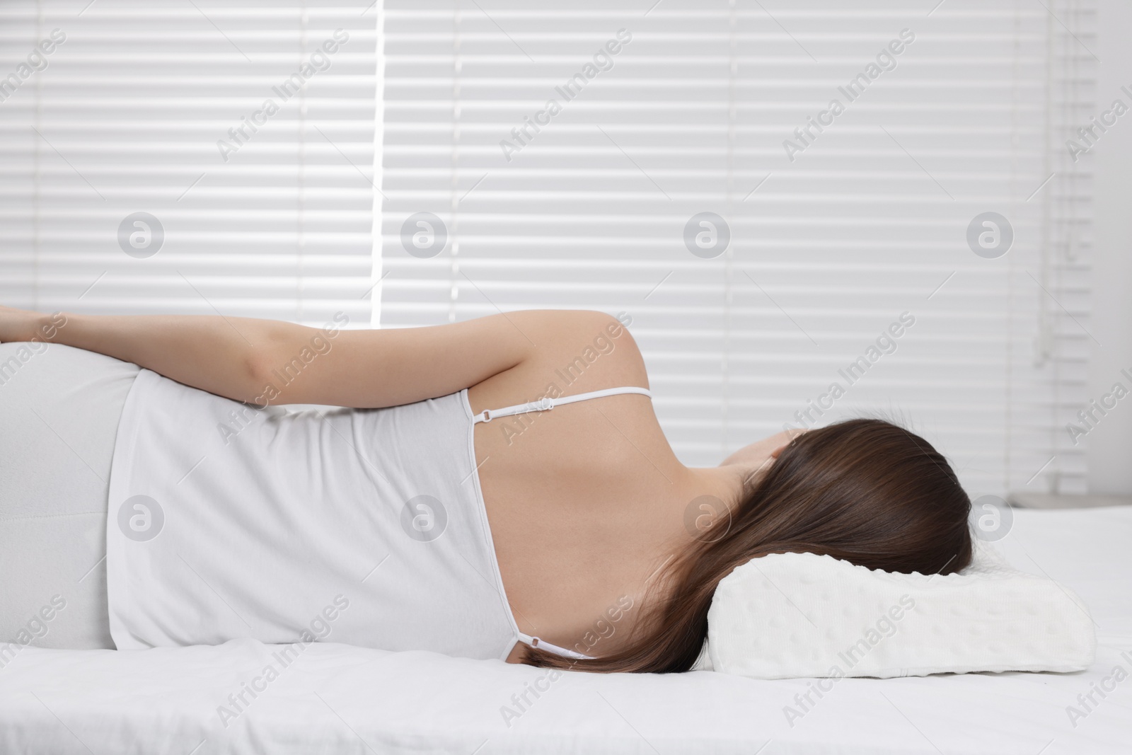 Photo of Woman sleeping on orthopedic pillow at home