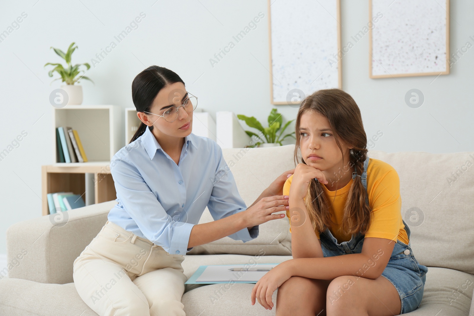 Photo of Young psychologist working with teenage girl in office