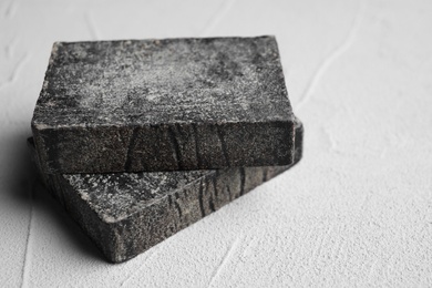 Photo of Natural tar soap on white table, closeup