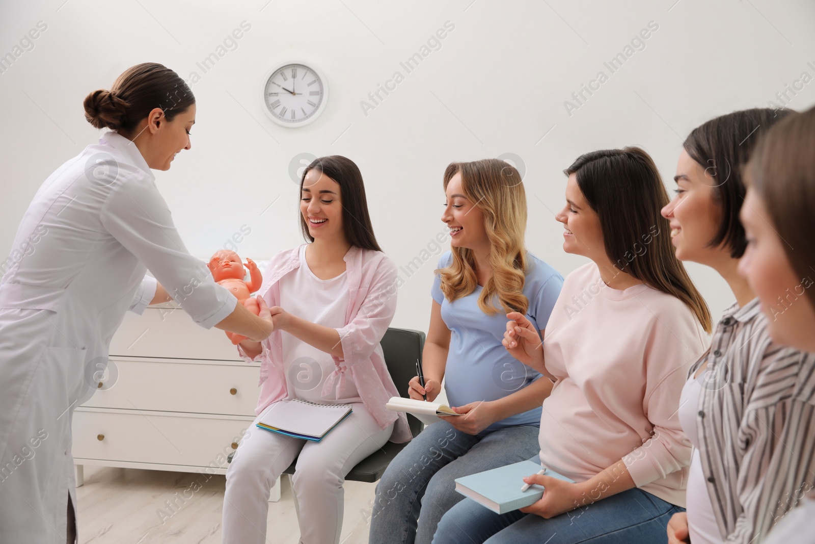 Photo of Group of pregnant women with doctor at courses for expectant mothers indoors