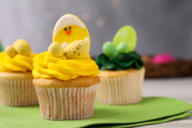 Photo of Tasty cupcakes with Easter decor on table, closeup