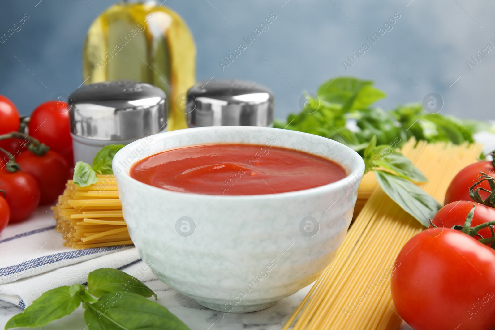Photo of Bowl of tasty tomato sauce and pasta served on table