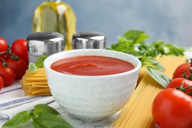 Bowl of tasty tomato sauce and pasta served on table