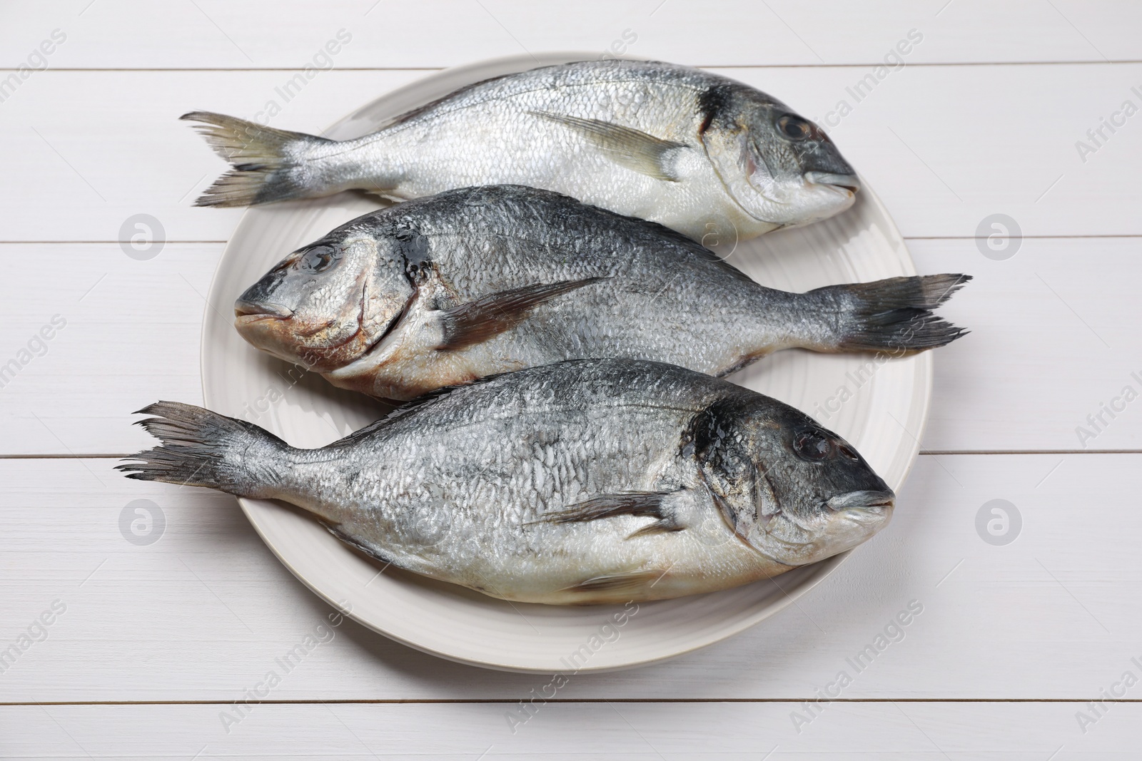 Photo of Fresh raw dorado fish on white wooden table