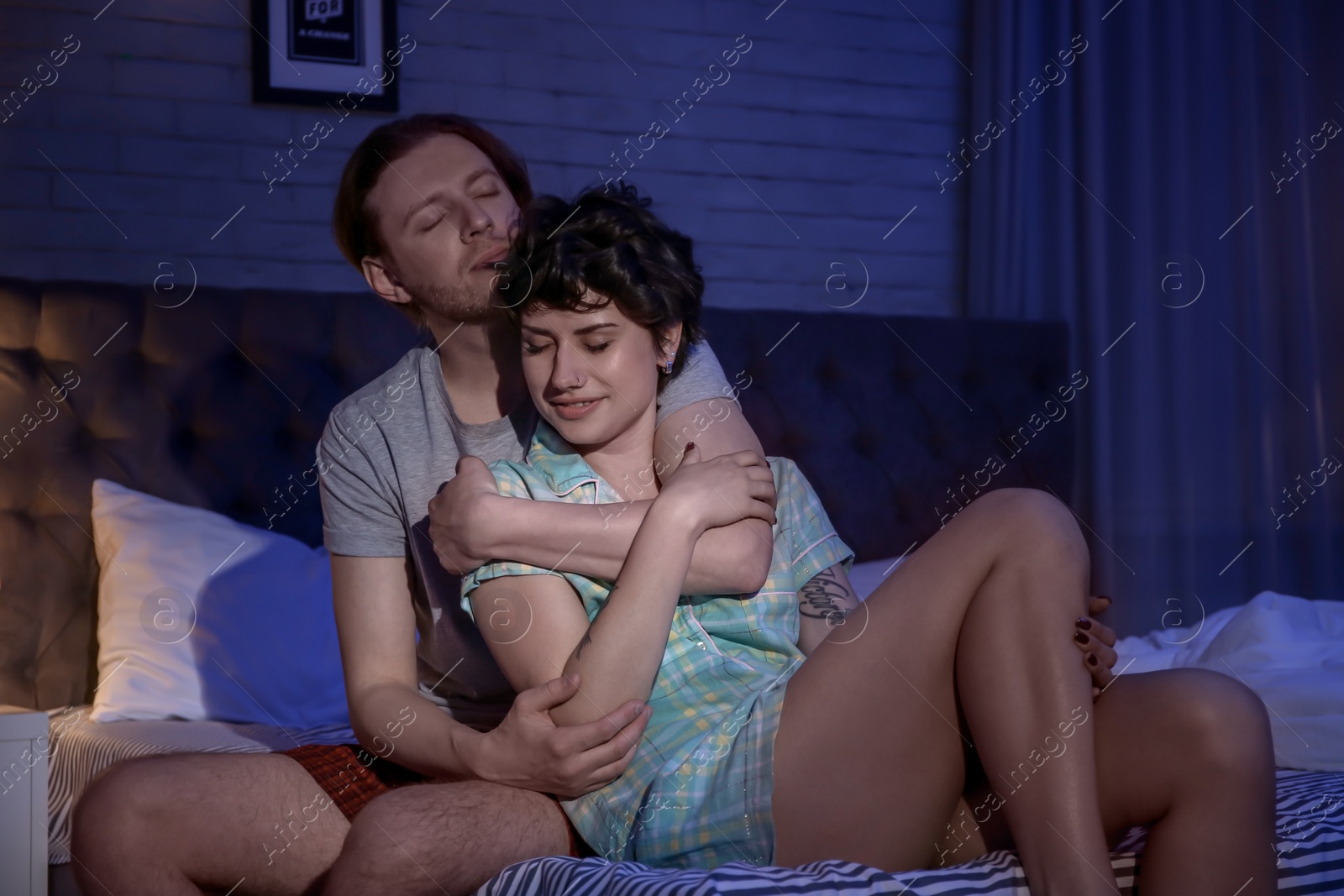 Photo of Lovely young couple on bed at night time