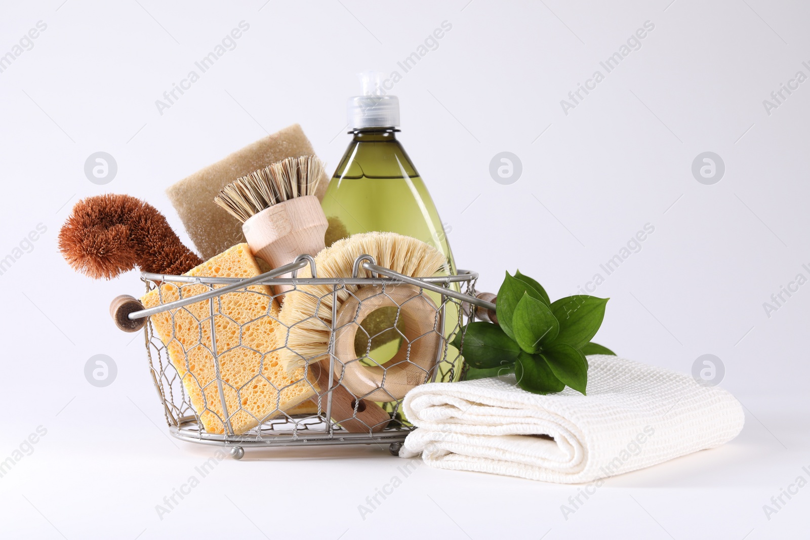 Photo of Set of different cleaning supplies in basket on white background