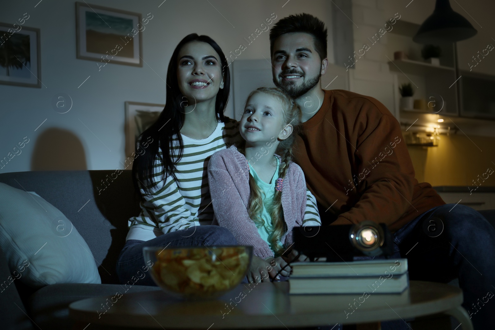 Photo of Family watching movie using video projector at home