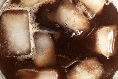 Coffee drink with ice cubes in glass, top view