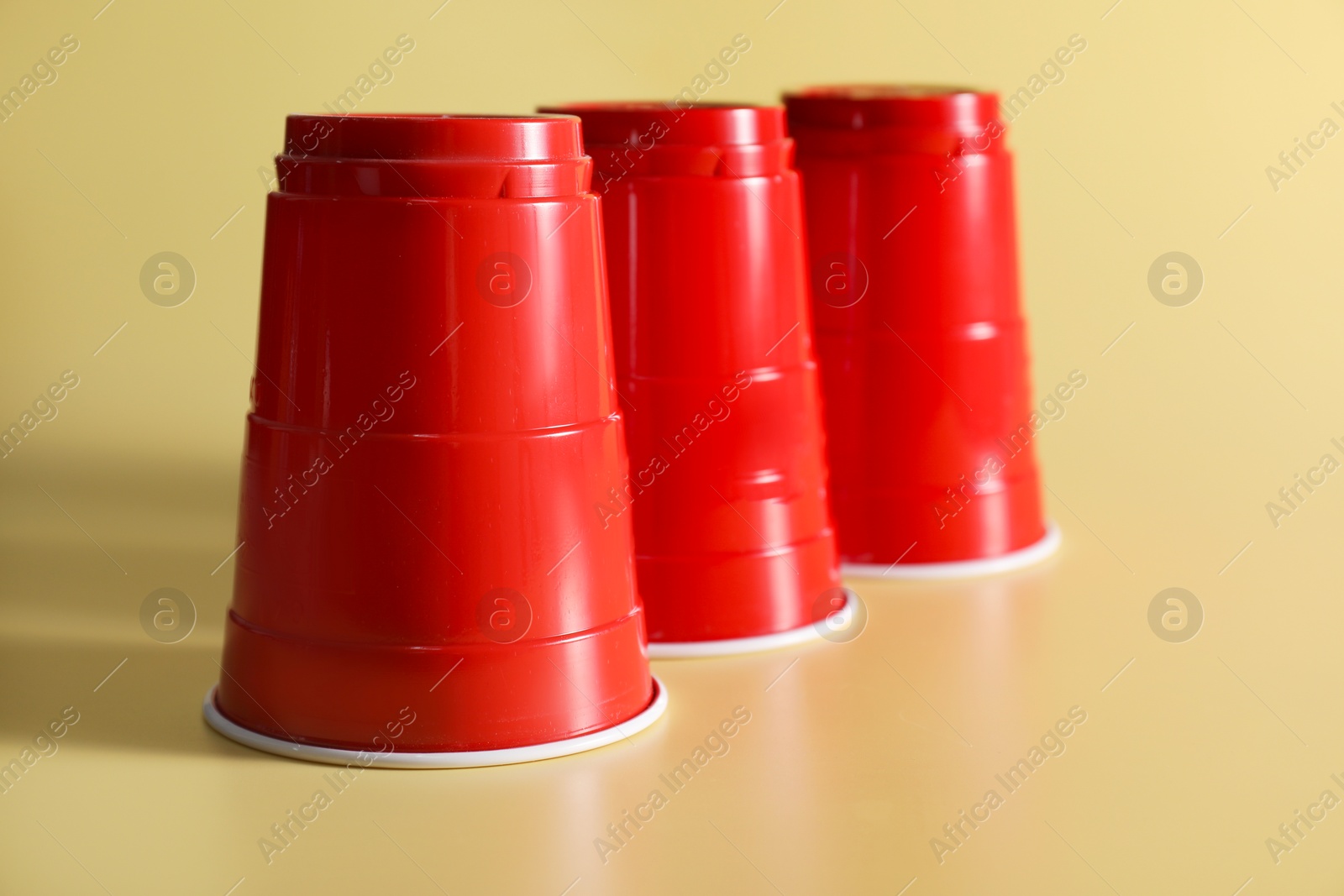 Photo of Shell game. Three red cups on yellow background