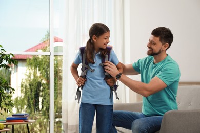 Photo of Father helping his daughter to get ready for school at home