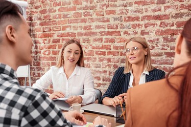 Photo of Businesswoman having meeting with her employees in office. Lady boss