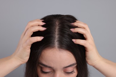 Woman with healthy hair on grey background, closeup