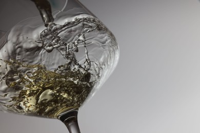 Photo of Tasty aromatic wine in glass on gray background, closeup. Space for text