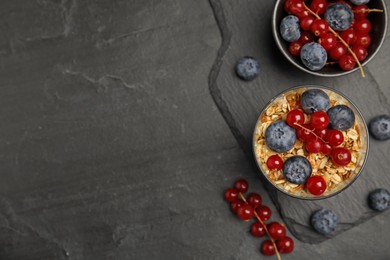 Photo of Delicious yogurt parfait with fresh berries on black table, flat lay. Space for text