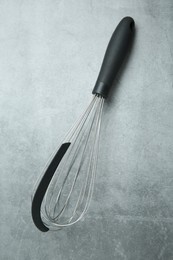 Metal whisk on gray table, top view