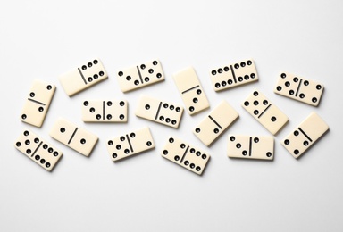 Classic domino tiles on white background, flat lay