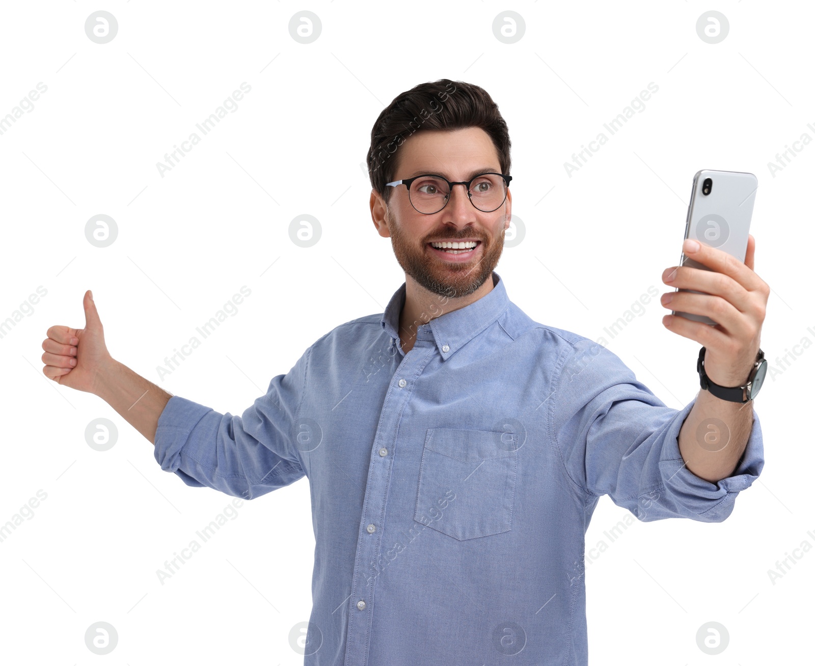 Photo of Smiling man taking selfie with smartphone and showing thumbs up on white background