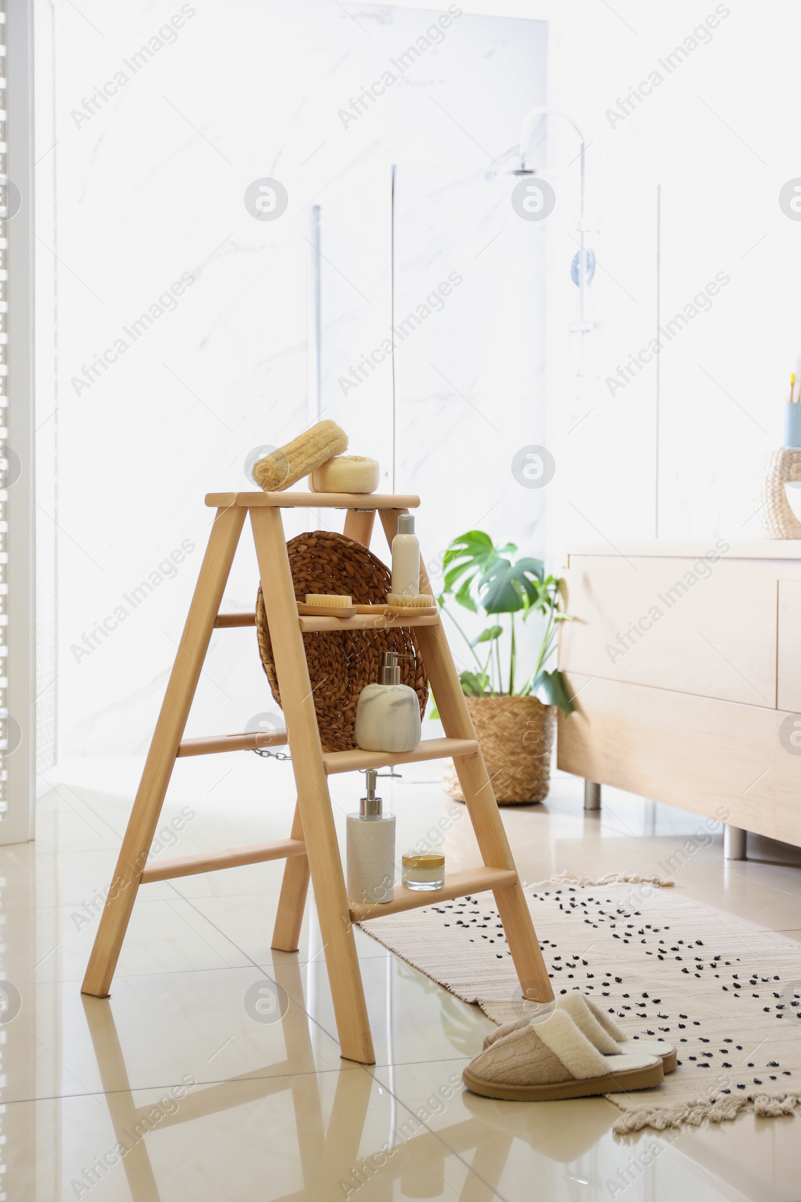 Photo of Dispensers and different toiletries on decorative ladder in bathroom. Idea for interior design