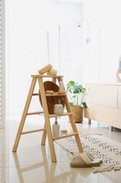 Dispensers and different toiletries on decorative ladder in bathroom. Idea for interior design
