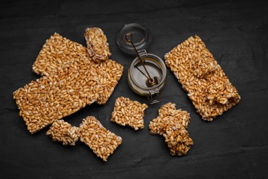 Puffed rice bars (kozinaki) on black table, flat lay