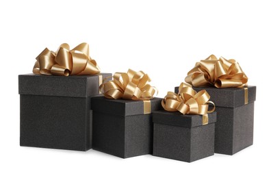 Black gift boxes with golden bows on white background