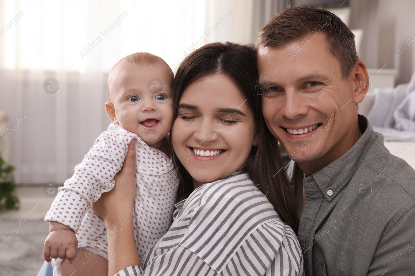 Photo of Happy family with their cute baby in living room at home