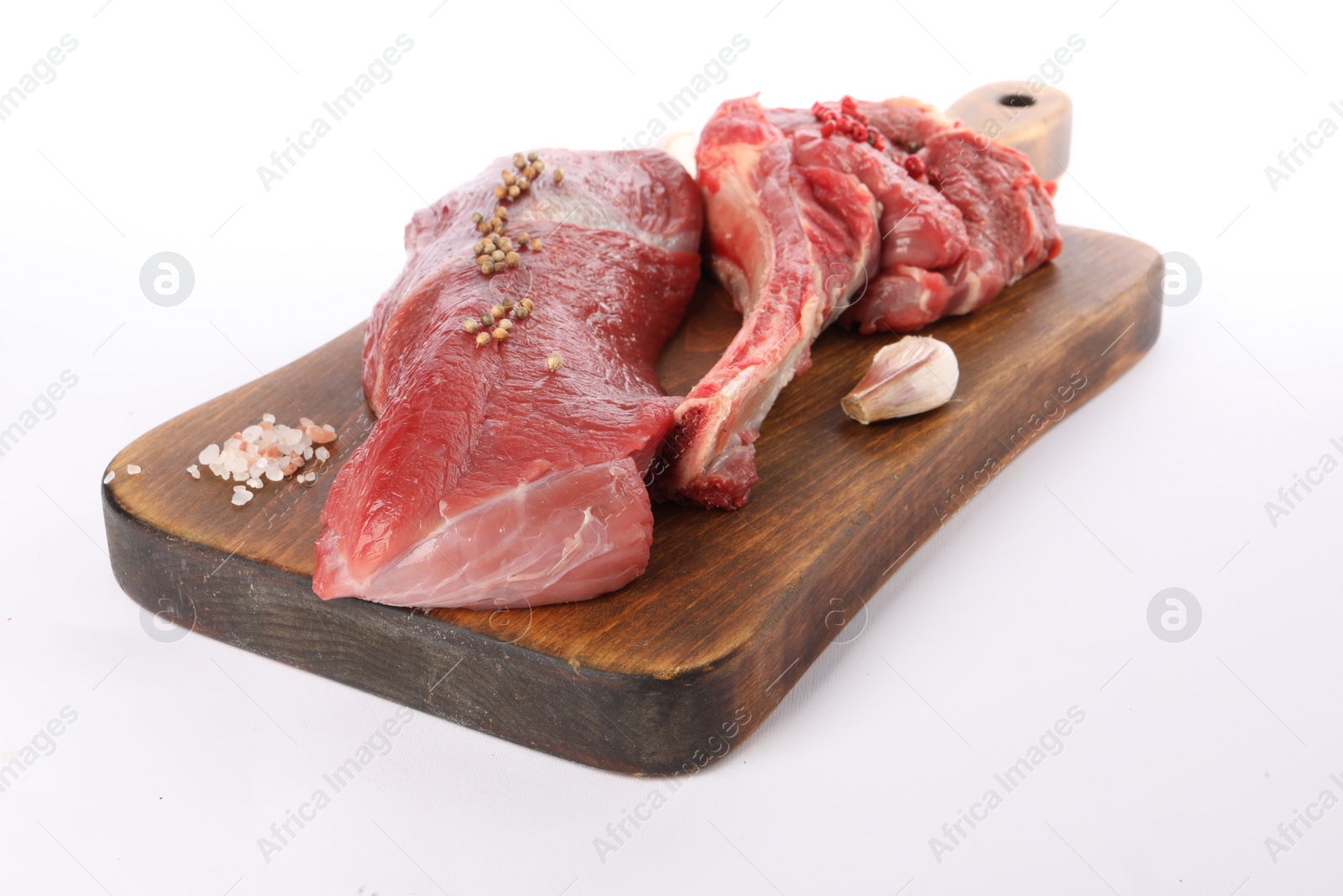 Photo of Board with pieces of raw beef meat and spices isolated on white