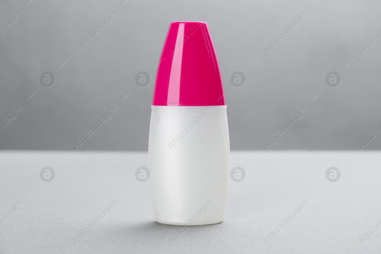 Photo of Bottle with insect repellent spray on grey background