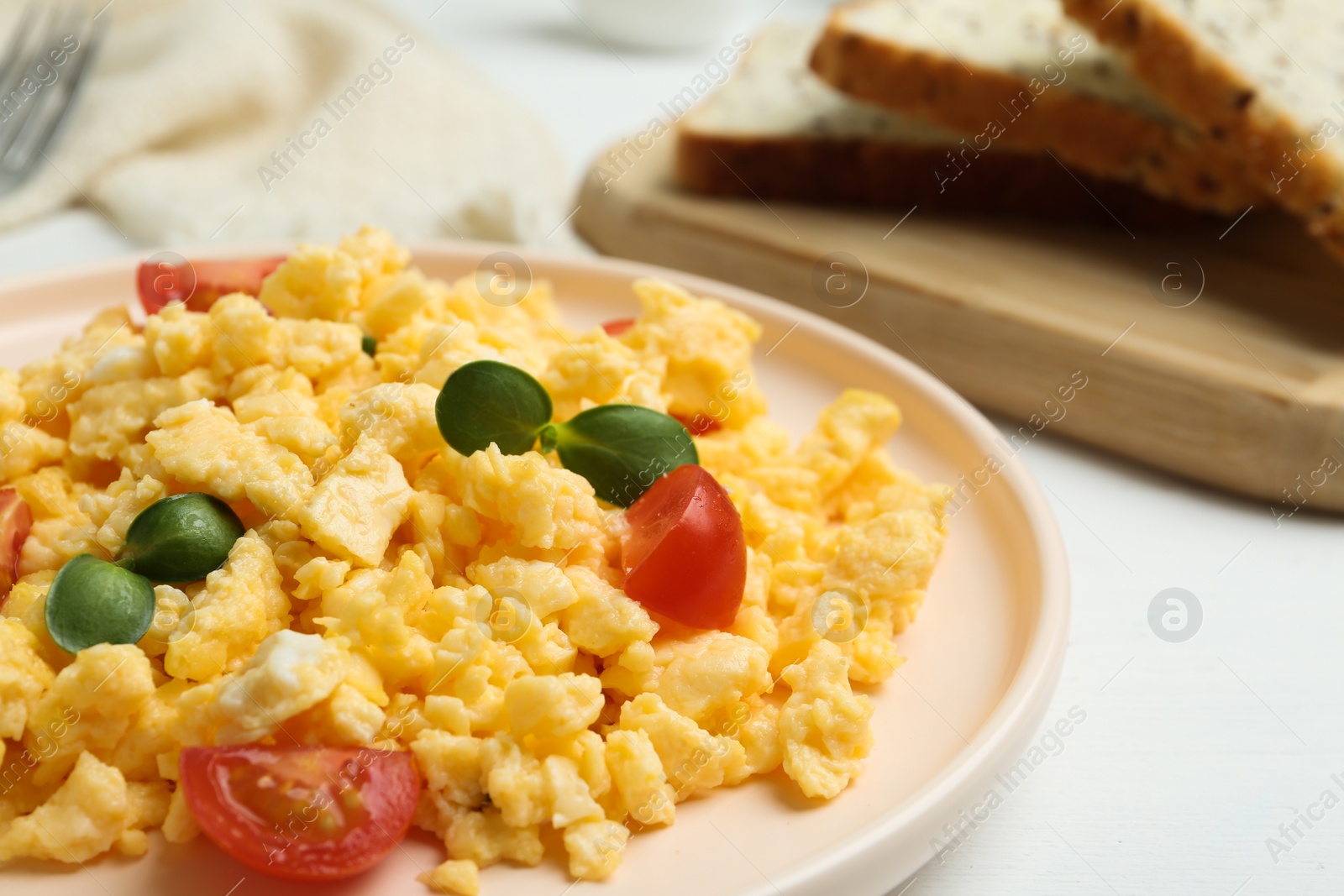 Photo of Tasty scrambled eggs with sprouts and cherry tomato on plate, closeup