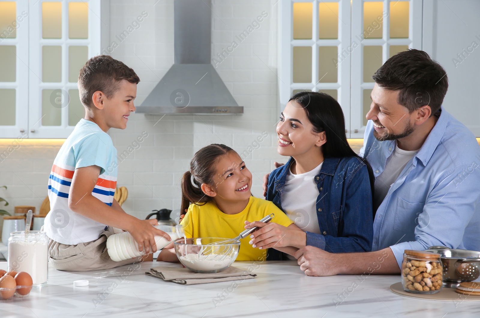 Photo of Happy family cooking together at table in kitchen. Adoption concept