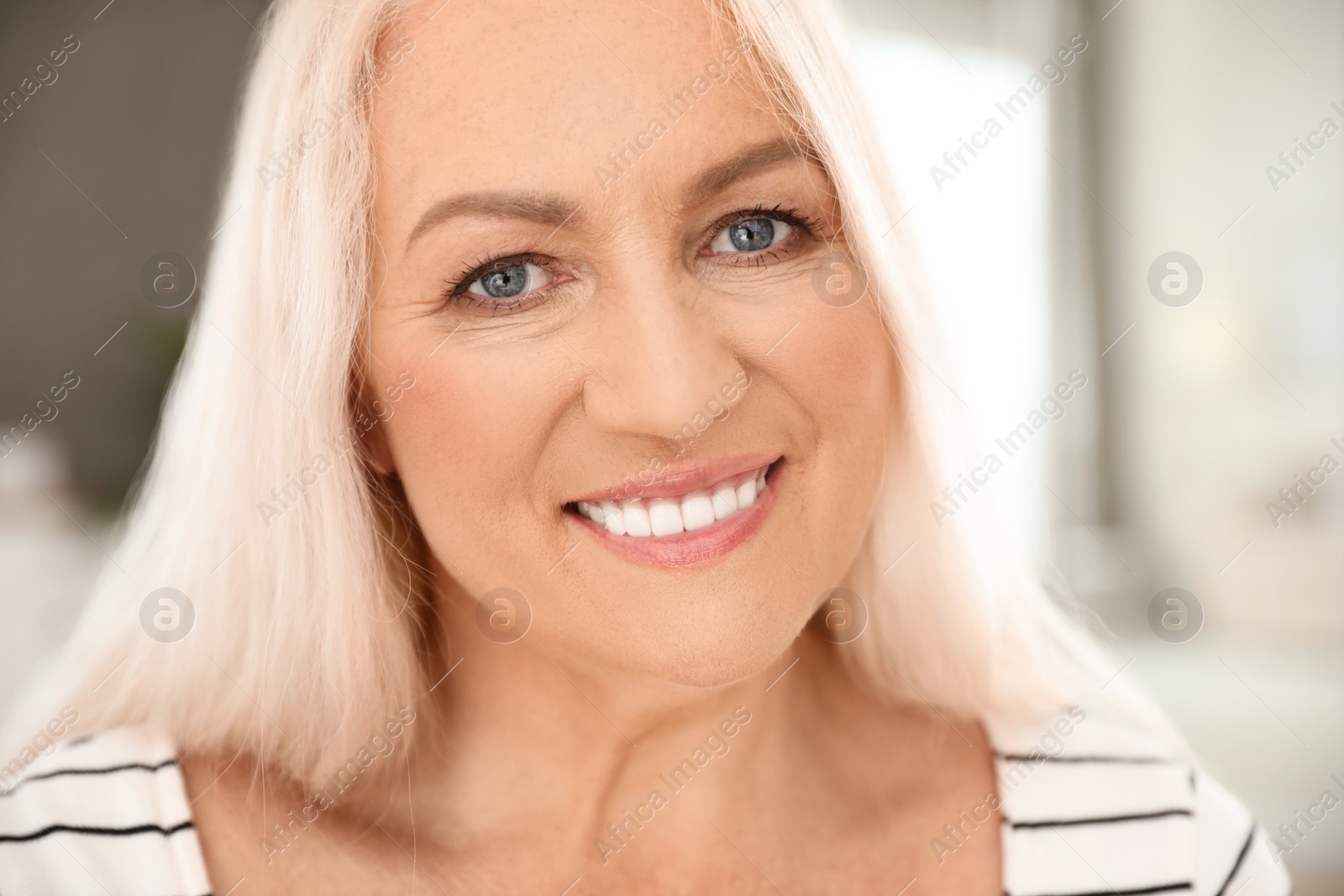 Photo of Portrait of mature woman with beautiful face on blurred background, closeup view