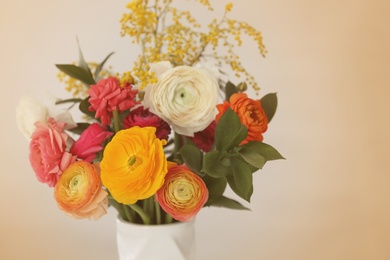 Photo of Vase with beautiful ranunculus flowers on light background